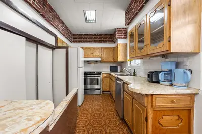a kitchen with wooden cabinets and a white refrigerator at Magnificent 4BR in Downtown Mont-Royal in Montréal