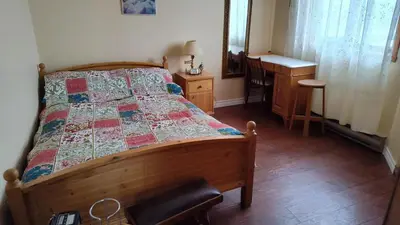 a bedroom with a bed and a desk and a sink at Family-Friendly in Quiet Laval Neighborhood in Laval