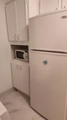 a white refrigerator in a kitchen with a microwave at Family-Friendly in Quiet Laval Neighborhood in Laval