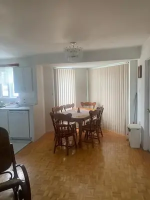 a dining room with a table and chairs and a kitchen at Family-Friendly in Quiet Laval Neighborhood in Laval