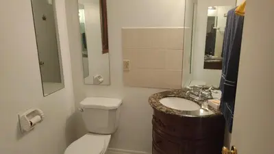 a bathroom with a white toilet and a sink at Family-Friendly in Quiet Laval Neighborhood in Laval
