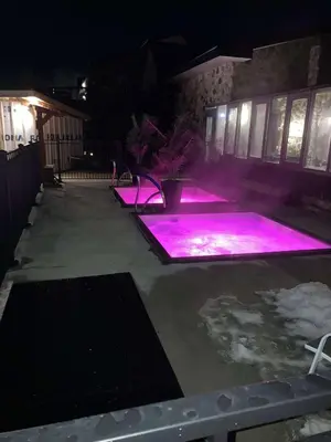 a pool with purple lights in a yard at night at L'intime loft Studio à Orford in Magog-Orford