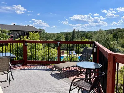a deck with chairs and tables and a fence at L'intime loft Studio à Orford in Magog-Orford
