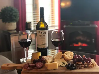 a bottle of wine and two glasses of wine and cheese at L'intime loft Studio à Orford in Magog-Orford