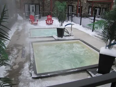 a hot tub in a yard covered in snow at L'intime loft Studio à Orford in Magog-Orford