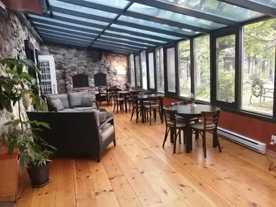 a living room with tables and chairs and a fireplace at L'intime loft Studio à Orford in Magog-Orford
