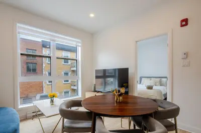 a living room with a table and chairs and a bedroom at Peaceful 1BR Getaway Near MTL Village in Montréal
