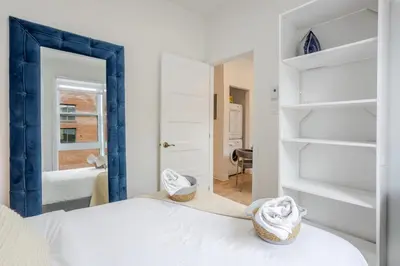 a bedroom with a white bed and a mirror at Peaceful 1BR Getaway Near MTL Village in Montréal