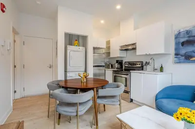 a kitchen and living room with a table and chairs at Peaceful 1BR Getaway Near MTL Village in Montréal