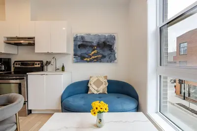 a living room with a blue chair and a table at Peaceful 1BR Getaway Near MTL Village in Montréal