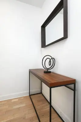 a wooden table with a mirror on a wall at Contemporary 2BR Retreat in MTL Village in Montréal