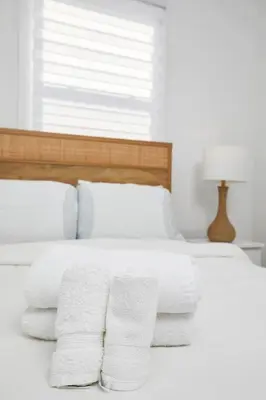 a white bed with towels on it with a window at Contemporary 2BR Retreat in MTL Village in Montréal