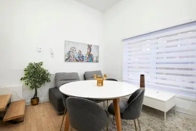 a dining room with a white table and chairs at Delightful 2BR in Village Downtown in Montréal