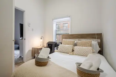 a bedroom with a large white bed with two chairs at Delightful 2BR in Village Downtown in Montréal