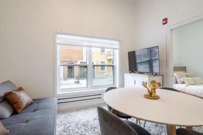 a living room with a table and a large window at Delightful 2BR in Village Downtown in Montréal