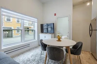 a living room with a table and chairs and a tv at Delightful 2BR in Village Downtown in Montréal
