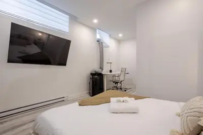 a white bedroom with a bed with two towels on it at Delightful 2BR in Village Downtown in Montréal