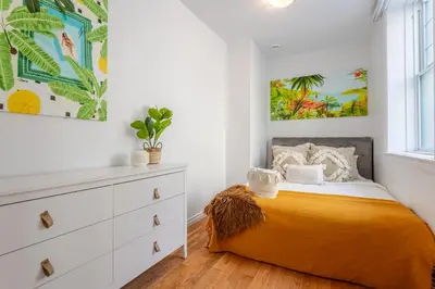 a bedroom with a bed and a dresser at Elegant 4 Bedroom residence in downtown MTL in Montréal