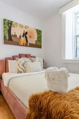 a bedroom with a large bed with a painting on the wall at Elegant 4 Bedroom residence in downtown MTL in Montréal