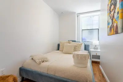 a small bedroom with a bed and a window at Elegant 4 Bedroom residence in downtown MTL in Montréal