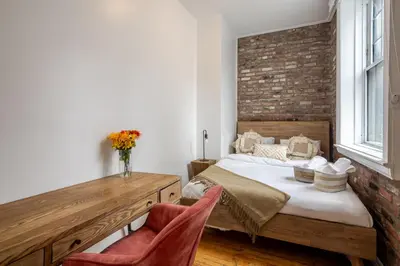 a bedroom with a bed and a brick wall at Chic 4BR Haven Sunlit in Downtown MTL in Montréal