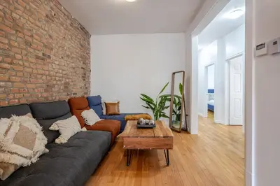 a living room with a couch and a brick wall at Chic 4BR Haven Sunlit in Downtown MTL in Montréal