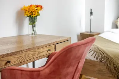 a wooden desk with a vase of flowers on it at Chic 4BR Haven Sunlit in Downtown MTL in Montréal