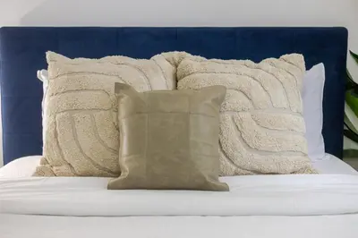 a bed with white pillows and a blue headboard at Chic 4BR Haven Sunlit in Downtown MTL in Montréal