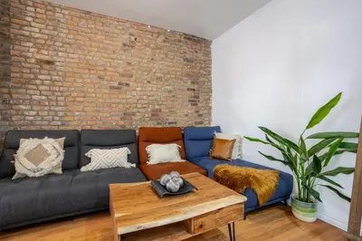 a living room with a couch and a brick wall at Chic 4BR Haven Sunlit in Downtown MTL in Montréal