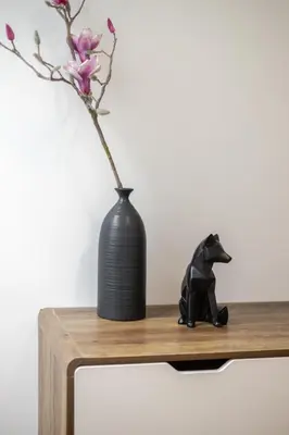 a black cat sitting on a wooden table next to a vase at Prime Location Charming 4BR in Downtown MTL in Montréal