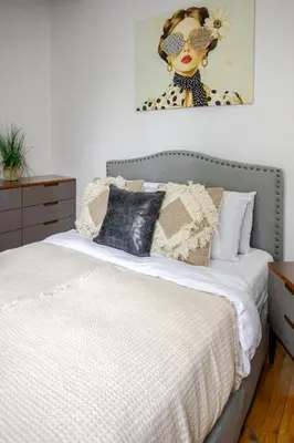 a bedroom with a bed and a picture of a woman at Prime Location Charming 4BR in Downtown MTL in Montréal