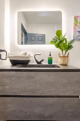 a kitchen counter with a sink and a mirror at Prime Location Charming 4BR in Downtown MTL in Montréal
