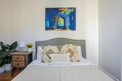 a bedroom with a bed with a painting on the wall at Prime Location Gorgeous 4BR Downtown MTL in Montréal
