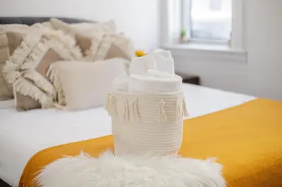 a stack of white towels sitting on top of a bed at Prime Location Gorgeous 4BR Downtown MTL in Montréal