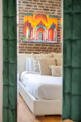 a white bed in a room with a brick wall at Prime Location Gorgeous 4BR Downtown MTL in Montréal