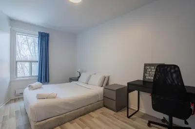 a bedroom with a bed and a desk and a chair at Excellent 4 Bedroom in Griffintown Downtown MTL in Montréal