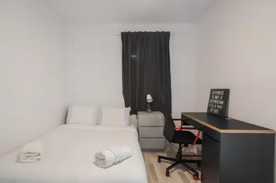 a bedroom with a bed and a desk with a computer at Excellent 4 Bedroom in Griffintown Downtown MTL in Montréal