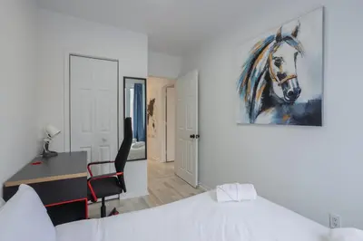 a bedroom with a bed and a painting of a horse at Excellent 4 Bedroom in Griffintown Downtown MTL in Montréal