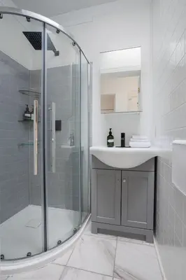 a bathroom with a sink and a glass shower at Excellent 4 Bedroom in Griffintown Downtown MTL in Montréal