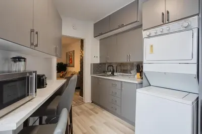a kitchen with white cabinets and a white refrigerator at Excellent 4 Bedroom in Griffintown Downtown MTL in Montréal
