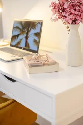 a desk with a laptop and a book and a vase of flowers at Downtown Hideaway Peaceful and Trendy in Montréal