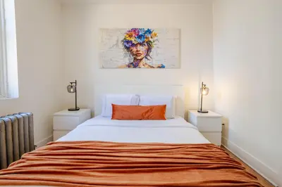 a bedroom with a bed with an orange pillow at Downtown Hideaway Peaceful and Trendy in Montréal