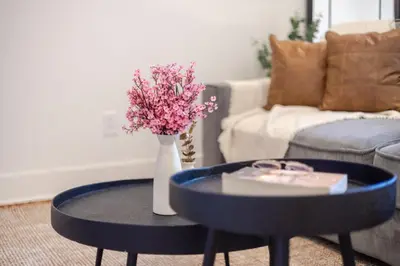 a living room with a table and a vase with flowers at Downtown Hideaway Peaceful and Trendy in Montréal
