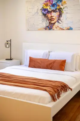 a bedroom with a bed with a painting on the wall at Downtown Hideaway Peaceful and Trendy in Montréal