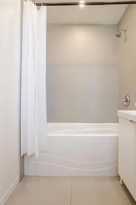 a white bathroom with a tub and a sink at Downtown Hideaway Peaceful and Trendy in Montréal