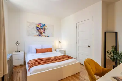 a white bedroom with a bed and a desk at Downtown Hideaway Peaceful and Trendy in Montréal
