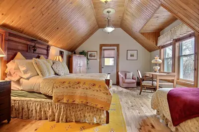 a bedroom with a bed and a table in a room at À L'Ancestrale B&B in Magog-Orford