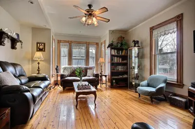 a living room with a couch and a ceiling fan at À L'Ancestrale B&B in Magog-Orford