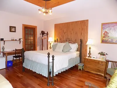 a bedroom with a large bed with a wooden headboard at À L'Ancestrale B&B in Magog-Orford