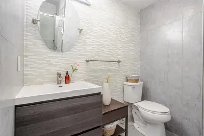 a bathroom with a toilet and a sink and a mirror at Chic DT MTL Condo with Rooftop, BBQ in Montréal